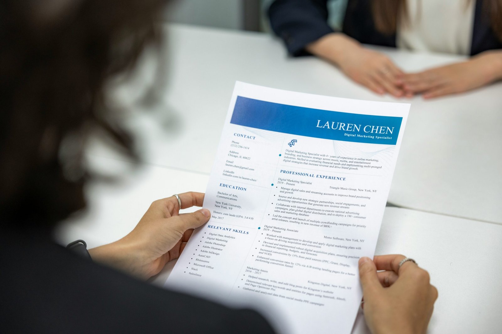 Hiring manager reviewing a resume with candidate contact details and address information