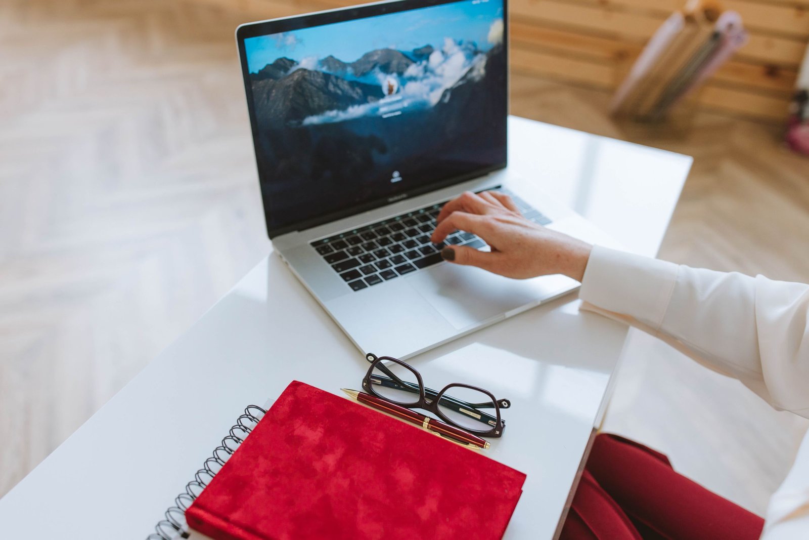 Person working at a laptop with a notebook, a realistic setup for AI training jobs done from home